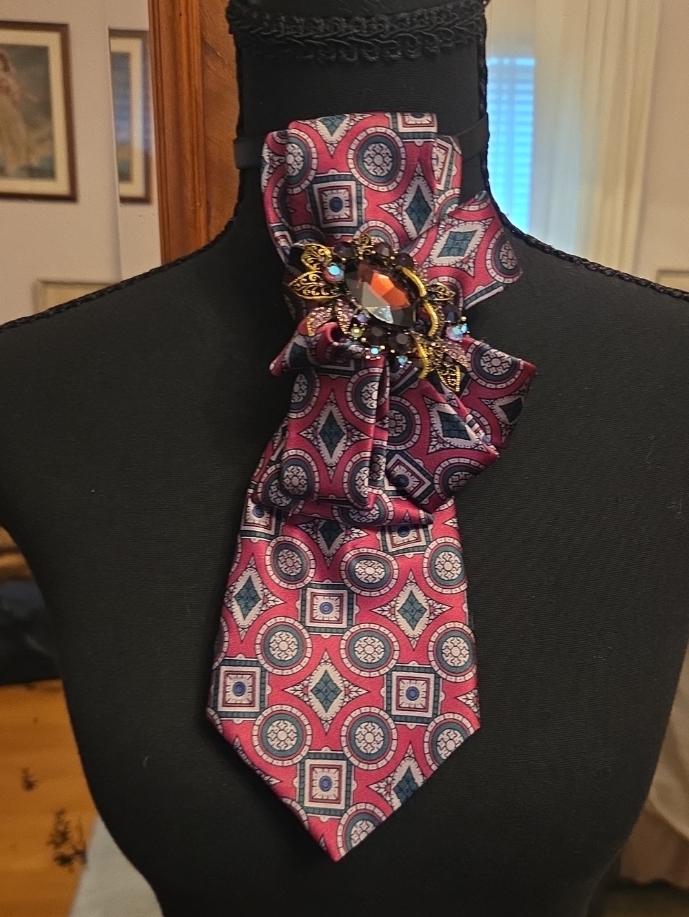 Vintage-Inspired Pink Patterned Silk Scarf with Decorative Brooch